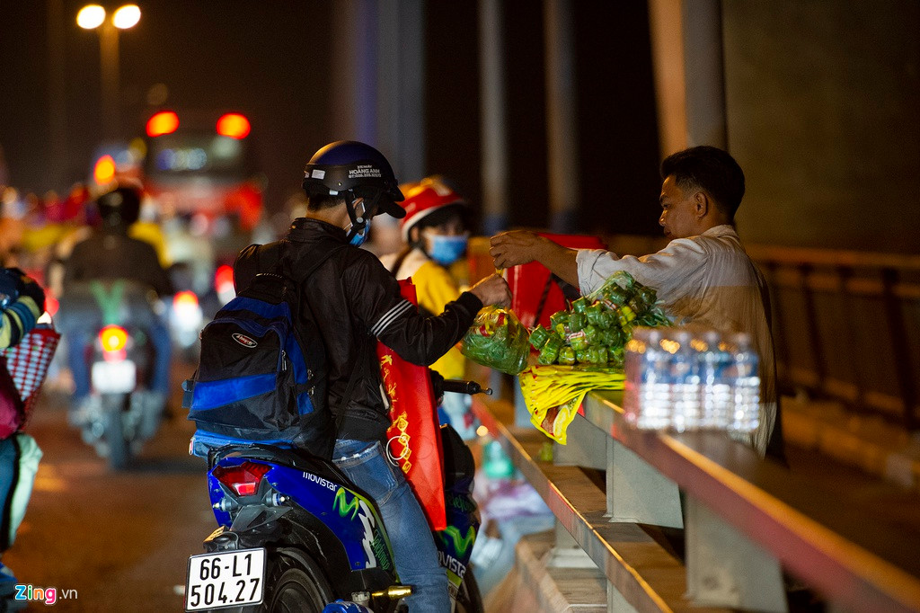 Một bạn trẻ tranh thủ mua nem từ người bán hàng rong. Việc buôn bán này không được phép trong những ngày thường và bị lực lượng chức năng nghiêm cấm để đảm bảo an toàn giao thông trên cầu.