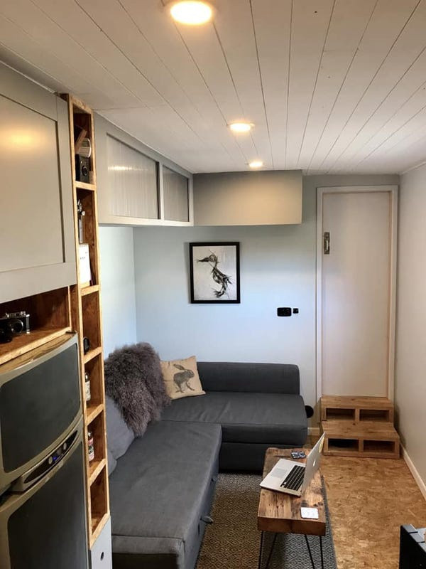 Phòng khách có một chiếc ghế bành và đầy đủ không gian cho bạn bè, gia đình đến thăm.