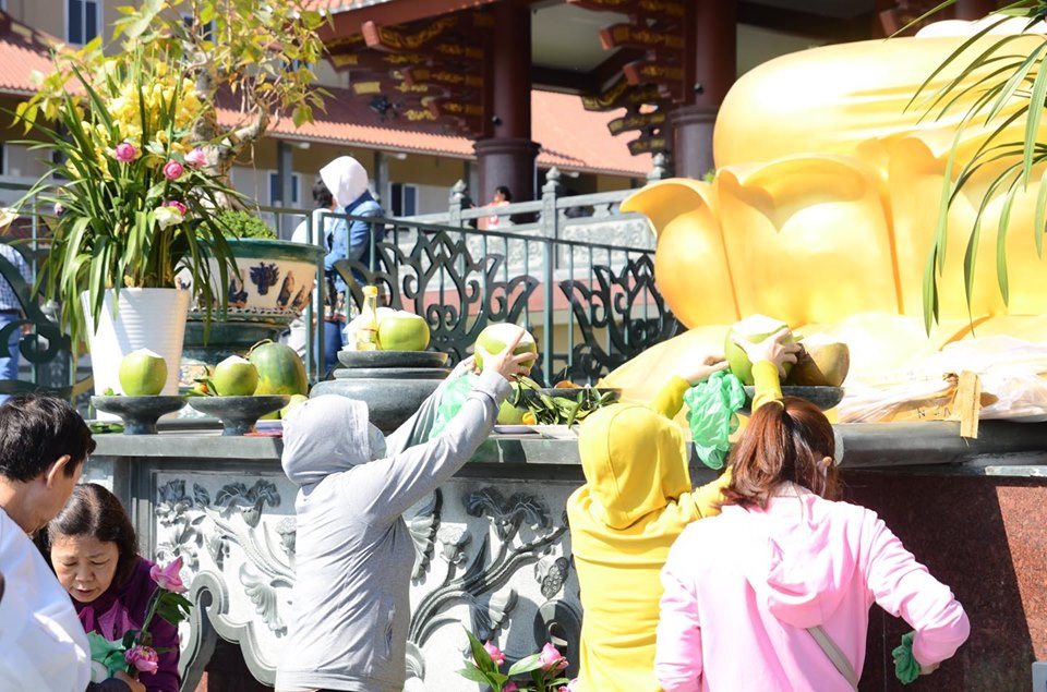 Một số người chuẩn bị mâm quả trước khi lễ Phật.