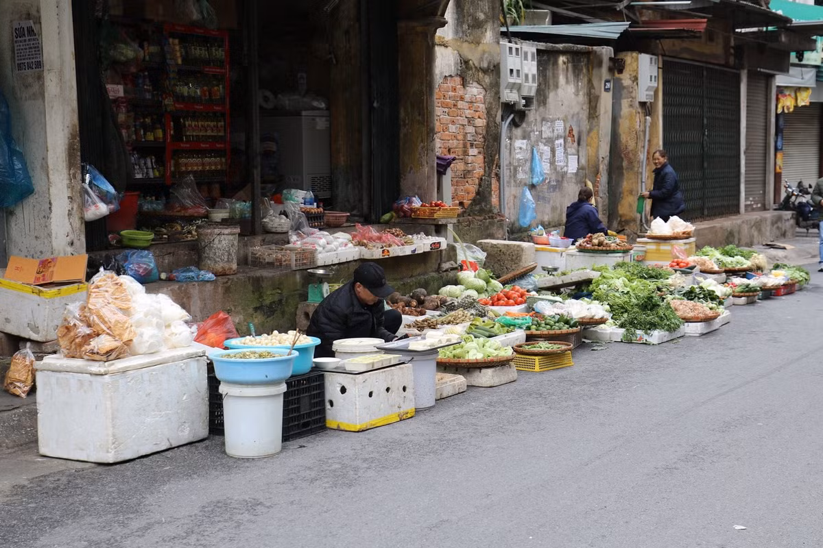 Khung cảnh đìu hiu trước một cửa hàng bán rau củ quả. Các tiểu thương tranh thủ chúc Tết, trao đổi với nhau giá cả các mặt hàng...