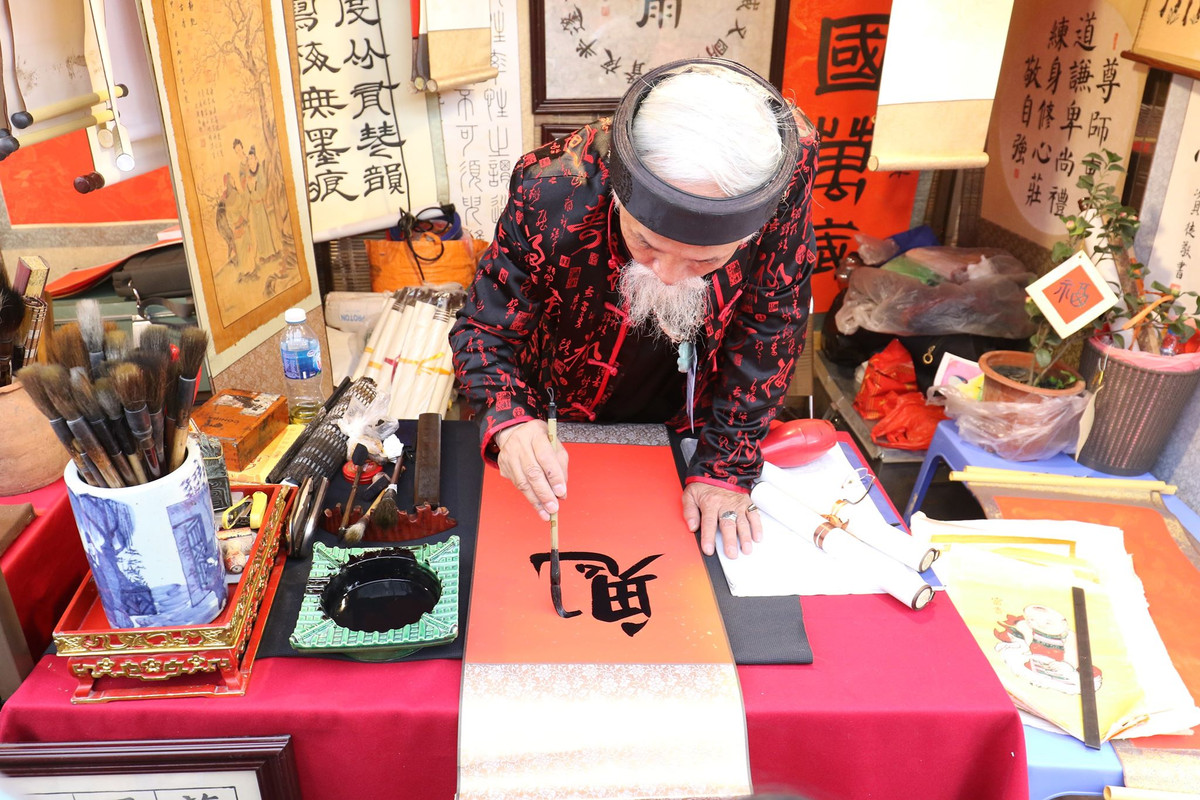 Nhiều người tới đây, dạo “phố ông đồ” để ngắm tranh chữ. Hay đơn giản chỉ là nghe các ông đồ giảng giải về nghệ thuật thư pháp.