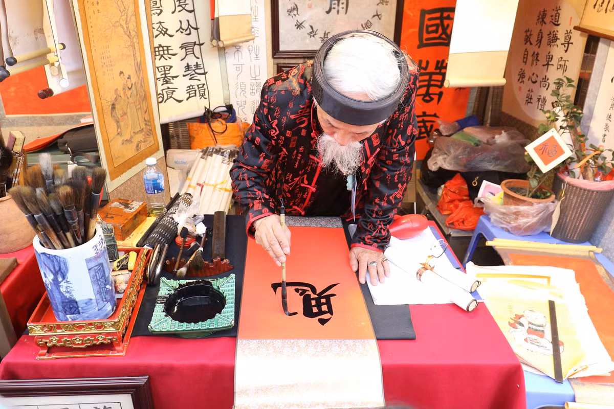 Nhiều người tới đây, dạo “phố ông đồ” để ngắm tranh chữ. Hay đơn giản chỉ là nghe các ông đồ giảng giải về nghệ thuật thư pháp.