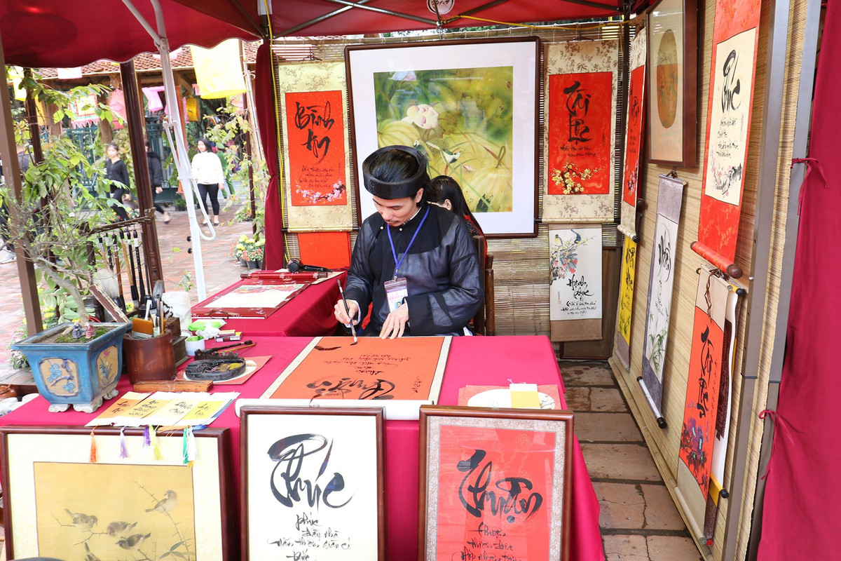 Dọc khắp bức tường Văn Miếu cổ kính, rêu phong, hàng trăm bức tranh chữ ẩn hiện trong làn mưa xuân tạo nên nét đặc trưng riêng cho Tết của Thủ đô Hà Nội.