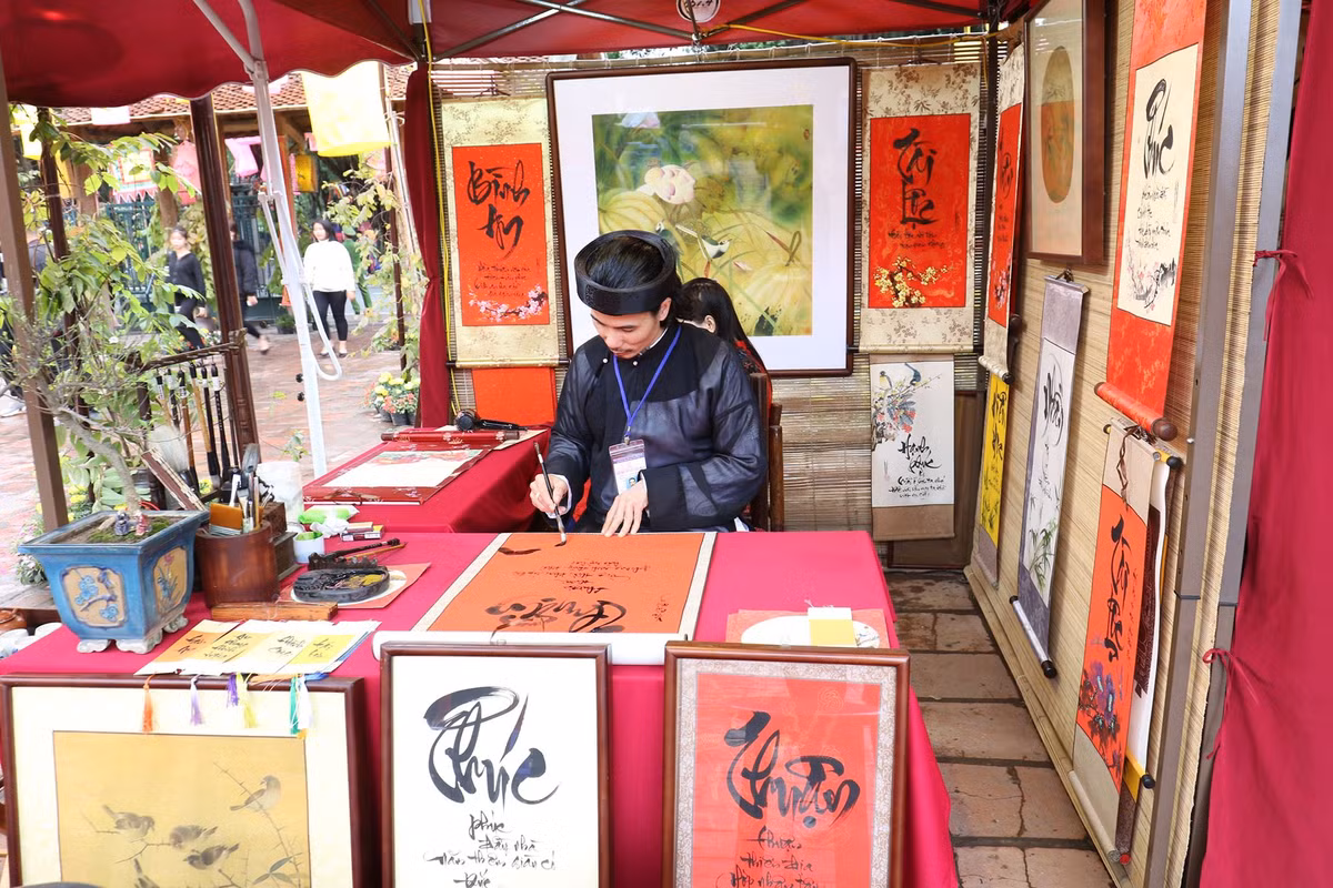 Dọc khắp bức tường Văn Miếu cổ kính, rêu phong, hàng trăm bức tranh chữ ẩn hiện trong làn mưa xuân tạo nên nét đặc trưng riêng cho Tết của Thủ đô Hà Nội.