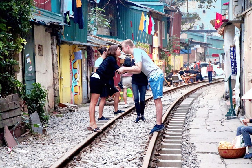 Du khách người nước ngoài còn bày tỏ tình cảm ngay trên đường ray tàu hỏa. (Ảnh: Vi Thương - Hải Yến/TTXVN).