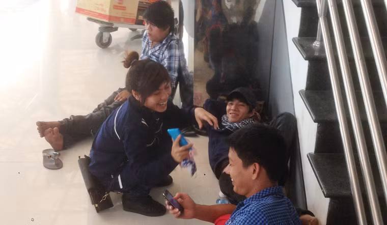 Hết ghế ngồi chờ vì quá đông, nhiều người phải nằm dài trên sàn nhà sân bay.