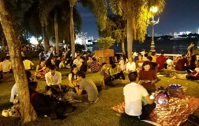 Giới trẻ ở TP HCM "mở tiệc" ngay tại các khu công viên ven bờ sông Sài Gòn để tận hưởng đêm Giao thừa, đón chờ thời khắc pháo hoa rực sáng trên bầu trời TP HCM.