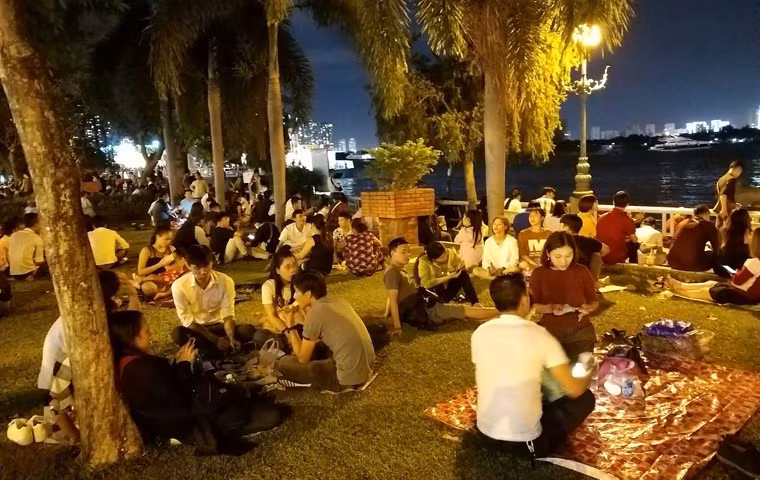 Giới trẻ ở TP HCM "mở tiệc" ngay tại các khu công viên ven bờ sông Sài Gòn để tận hưởng đêm Giao thừa, đón chờ thời khắc pháo hoa rực sáng trên bầu trời TP HCM.