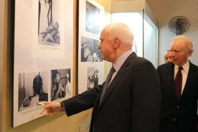 Ông McCain chỉ vào bức ảnh trong Nhà từ Hỏa Lò ghi lại thời điểm khi ông được điều trị vết thương năm 1967.