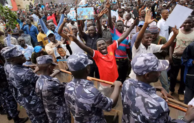 Người ủng hộ đảng FDC đối lập hô vang trước hàng rào cảnh sát ở Kampala ngày 15/2.