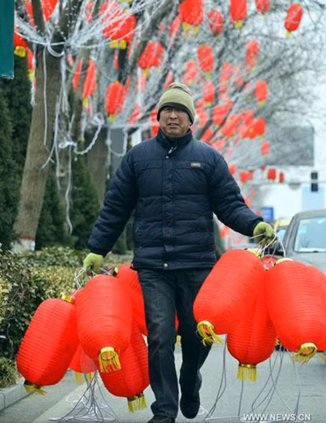 Người công nhân đi treo đèn lồng đỏ ở Liêu Thành, tỉnh Sơn Đông, ngày 30/1 để chào mừng năm mới 2016.
