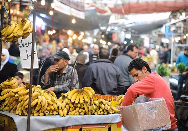Một người đàn ông Syria đang bày biện những nải chuối ra bán.