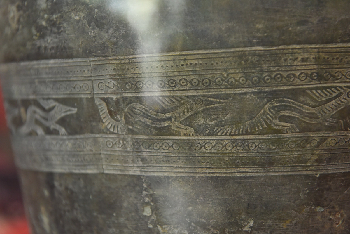 Thạp có băng hoa văn ở giữa thân, trang trí 14 con thú trong tư thế đuổi nhau, ngược chiều kim đồng hồ. Thú có miệng dài, thân dài và cong, đuôi dài to, bốn chân có móng rõ ràng, phía sau đầu có bờm (mào) dài. Đến nay, đây là thạp đồng Đông Sơn duy nhất ở Việt Nam có trang trí băng hoa văn này. Đôi quai kép hình mui thuyền gắn nằm ngang, khác với quai dọc thân như các thạp khác. Ngoài ra có băng hoa văn vòng tròn đồng tâm, hồi văn chữ S, trám lồng (hình thoi).