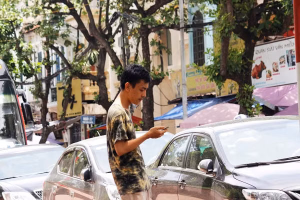 Nam thanh niên đứng dưới nắng nóng chang chang săn thú cưng.