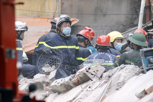 Lực lượng tìm kiếm các nạn nhân vụ sập nhà tập trung luân phiên nhau vận chuyển những tảng đá, bê tông, gạch... ra ngoài để cứu nạn.