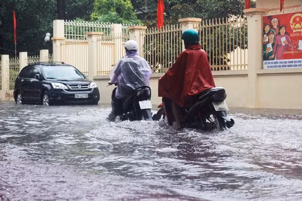 Nhiều phương tiện di chuyển khó khăn trong đoạn đường ngập sâu trước cửa UBND phường Nghĩa Tân.