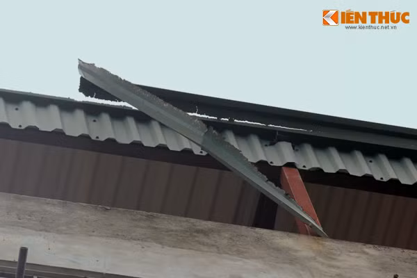Mái tôn trên tầng thượng cũng bị hư hỏng do nhà nghiêng vẹo.