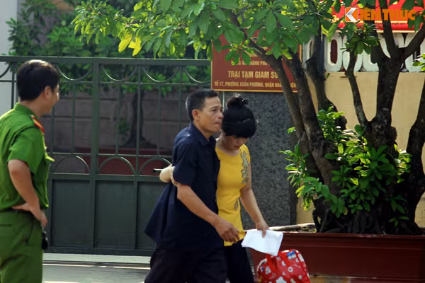 Người phụ nữ rưng rưng nước mắt, một tay ôm chặt người thân sau khi rời khỏi trại.