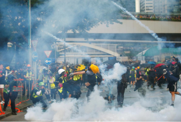 Những người biểu tình ném trả lựu đạn hơi cay về phía lực lượng cảnh sát gần trụ sở chính quyền Hong Kong ngày 15/9.