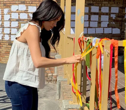 Công nương Meghan đã thắt một dải ruy băng vào nơi mà Mrwetyana bị sát hại và bày tỏ lời chia buồn sâu sắc với mẹ của nạn nhân. Được biết, Uyinene Mrwetyana đã bị cưỡng hiếp và sát hại hồi tháng 8/2019, làm dấy lên sự phẫn nộ trên toàn đất nước Nam Phi. Ảnh: Metro.