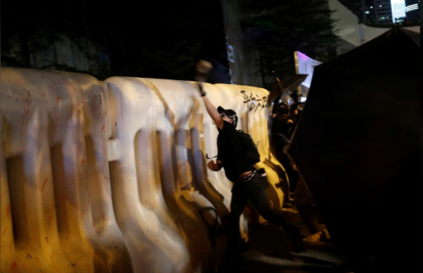 Một người biểu tình chống chính phủ ném vật thể trong cuộc tuần hành bên ngoài tòa nhà Hội đồng Lập pháp Hong Kong ngày 28/9.