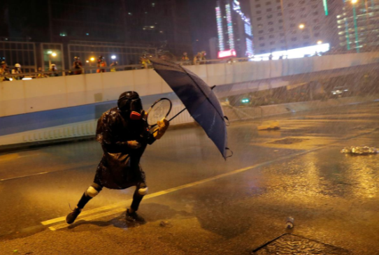 Người biểu tình dùng ô để chống lại vòi rồng của cảnh sát.