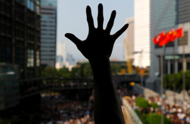 Người biểu tình Hong Kong giơ 5 ngón tay tượng trưng cho 5 yêu cầu đối với chính quyền khi tuần hành tới lãnh sự quán Mỹ ở Hong Kong hôm 8/9.