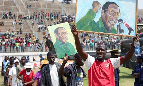Người ủng hộ diễu hành mang theo ảnh của ông Mugabe. Ảnh: Sky News.