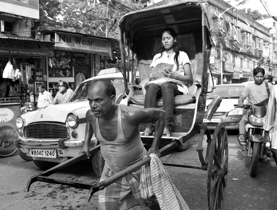 Bằng sức người, họ kéo xe di chuyển trên đường phố đông đúc ở Kolkata. 