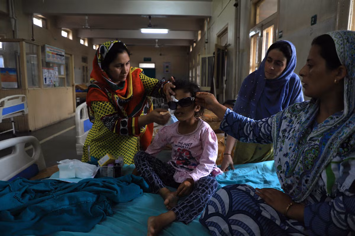 Người thân chăm sóc cho bé Munifa Nazir, 6 tuổi, tại bệnh viện Shri Maharaja Hari Singh ở Srinagar hôm 17/8. Bé gái đến từ Safakadal này đã bị thương bên mắt phải trong cuộc xung đột tại Kashmir.