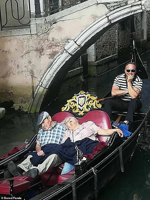 Hai du khách lớn tuổi ngủ quên khi đang ngồi trên thuyền đi ngắm cảnh ở Venice, Italy.