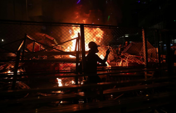 Người biểu tình Hong Kong đi qua đống lửa cháy dữ dội trên đường phố.