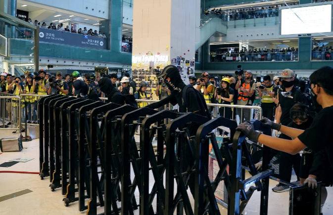 Người biểu tình dựng rào chắn ngăn cảnh sát tiến vào trung tâm thương mại New Town Plaza ngày 22/9.