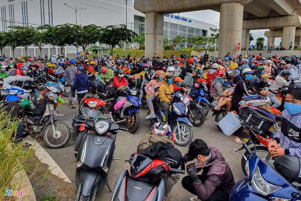 Phía trước cổng Bến xe Miền Đông cũng tập trung đông người muốn rời TP.HCM. Những người này đa phần có quê miền Trung. Khi nghe TP.HCM áp dụng cách ly xã hội thêm một tháng, họ quyết định khăn gói về quê. 