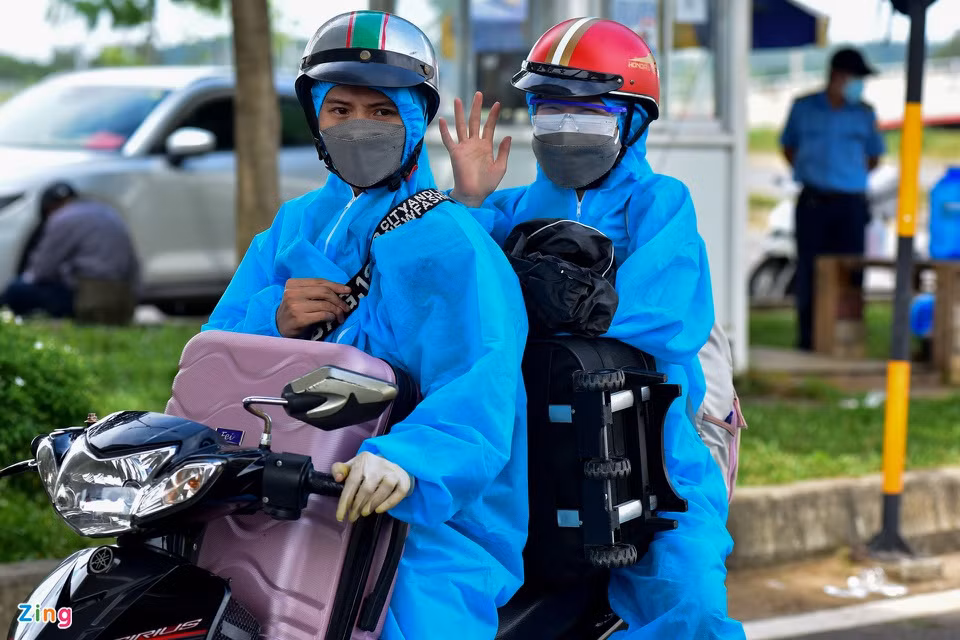 Hai thanh niên chở theo đồ đạc lỉnh kỉnh. Để đảm bảo an toàn, họ mặc đồ bảo hộ kỹ càng.