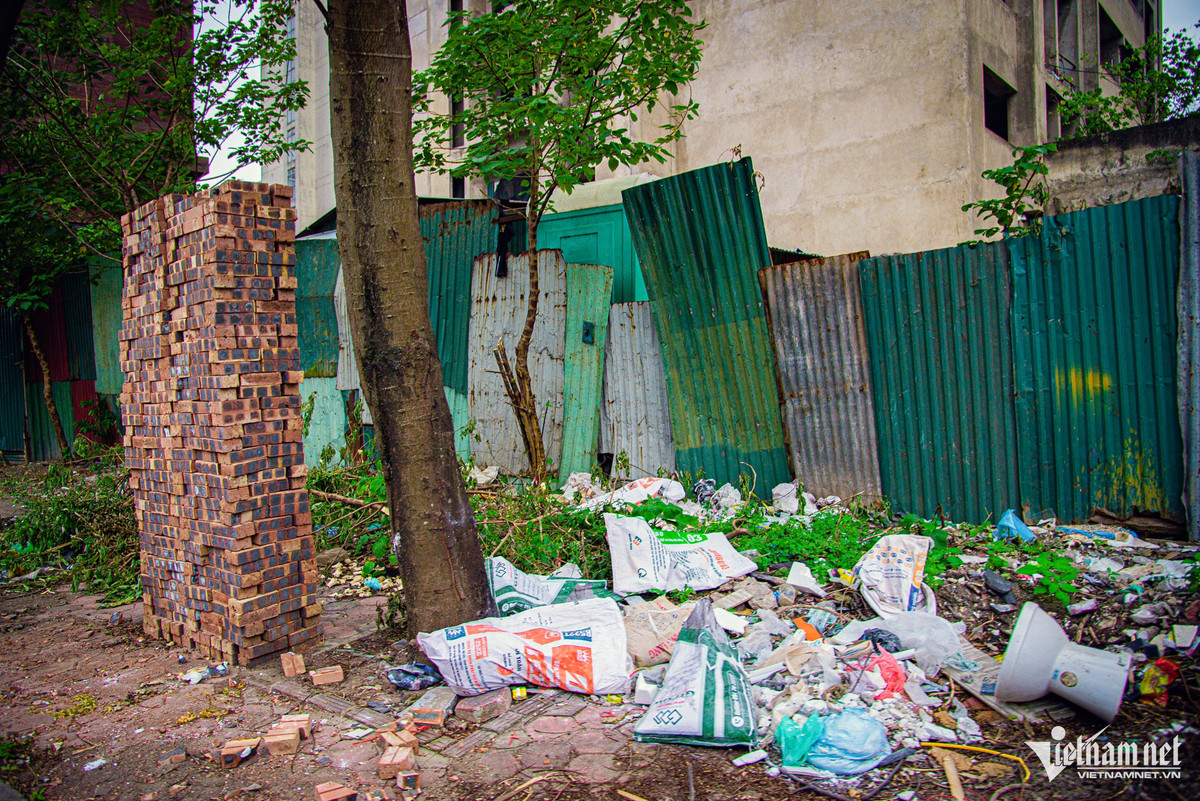 Khu ký túc xá được che chắn bằng lớp tường tôn xộc xệch và rác thải xây dựng tràn ngập. Các lối ra vào xung quanh vẫn trong tình trạng “cửa đóng then cài” nhiều năm nay.