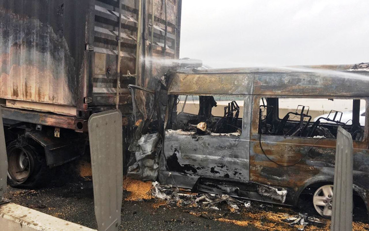 Cảnh hãi hùng chiếc xe khách cắm chặt vào xe đầu kéo container rồi cháy rụi. Thùng container cũng bị cháy.