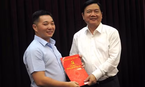 Bí thư Thành ủy TP HCM Đinh La Thăng (phải) trao quyết định cho ông Lê Trương Hải Hiếu.