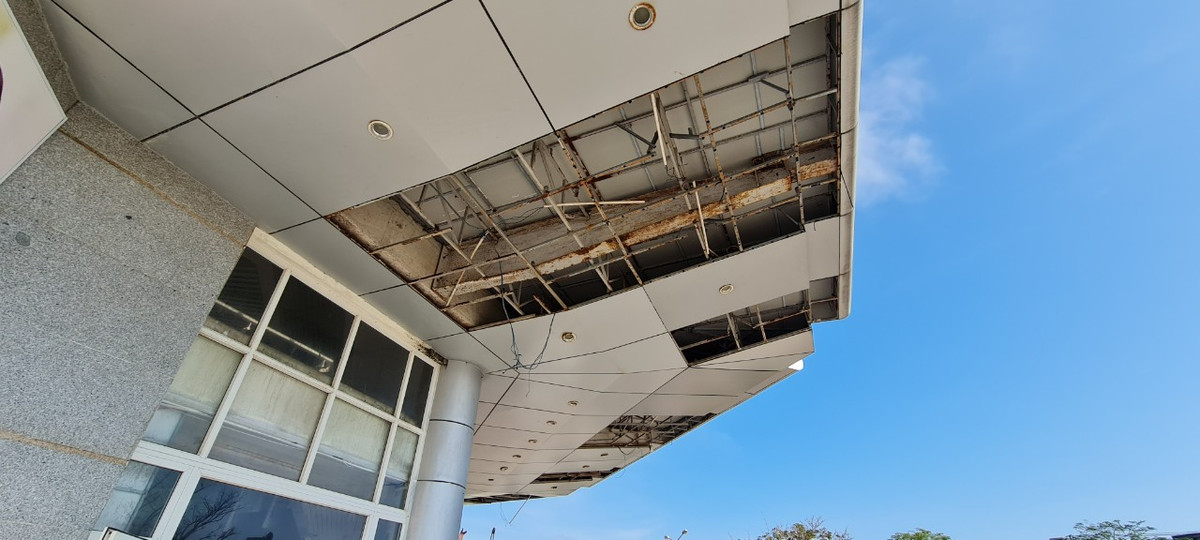 Các tấm ốp trần rơi rụng để lộ khung sắt rỉ sét bên trong.