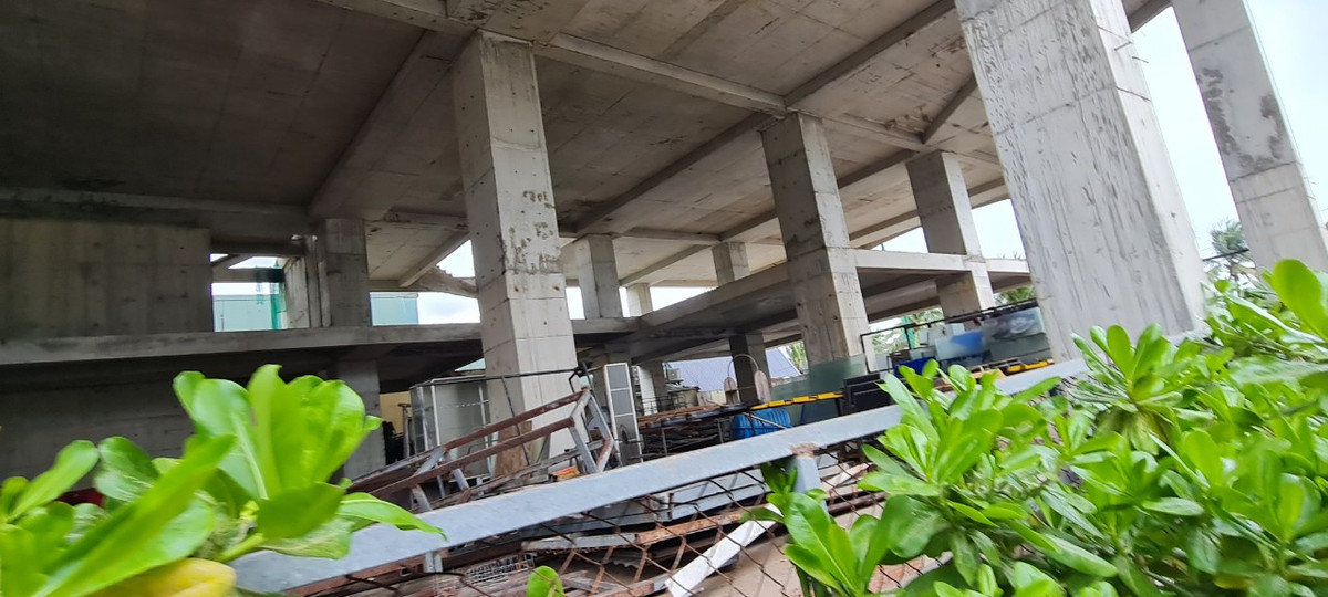 Tầng trệt được tận dụng làm kho chứa đồ, sắt thép đã đổi màu theo thời gian.