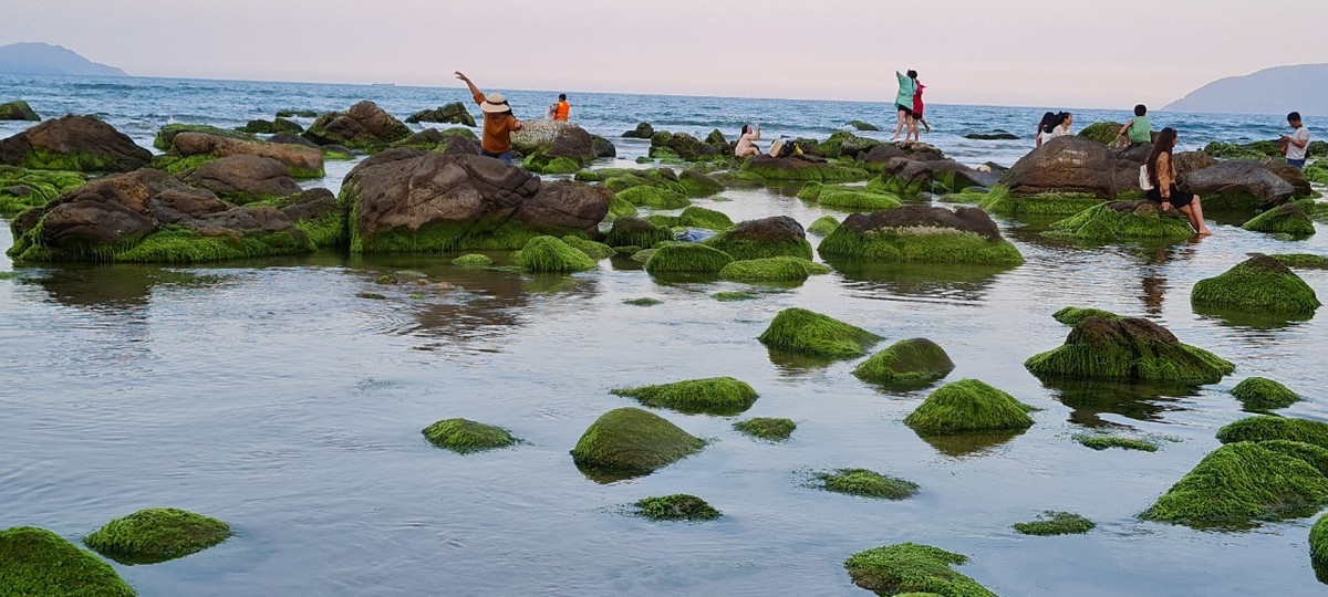 Ghềnh Nam Ô trong sắc hồng đậm dần của ánh mặt trời giữa làn mây mờ phía núi xa xa, sóng nước vỗ mạn đá tạo nên vũ điệu khi mềm mại, uyển chuyển.