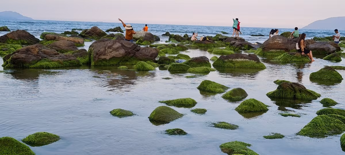 Ghềnh Nam Ô trong sắc hồng đậm dần của ánh mặt trời giữa làn mây mờ phía núi xa xa, sóng nước vỗ mạn đá tạo nên vũ điệu khi mềm mại, uyển chuyển.