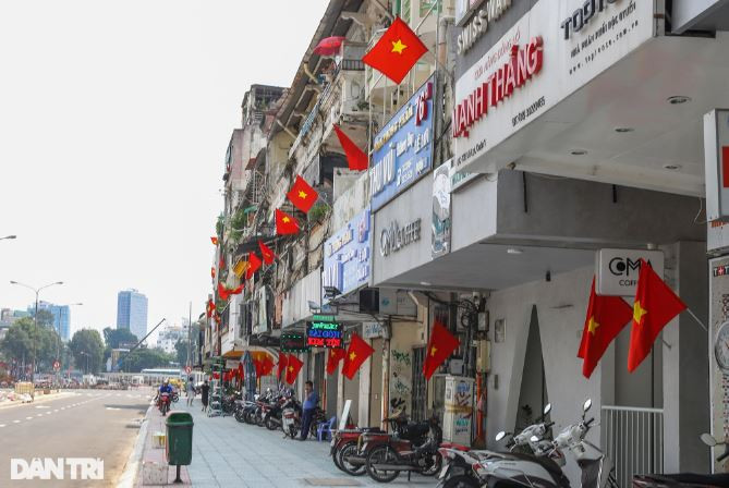 Người dân đường Lê Lợi (quận 1) treo cờ Tổ quốc trước dịp lễ. Con đường này vừa được hoàn trả mặt bằng sau nhiều năm bị lô cốt thi công tuyến metro số 1 (Bến Thành - Suối Tiên) án ngữ (Ảnh: Quang Ninh).