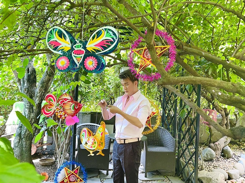 Nam ca sĩ tự tay treo đèn Trung thu lên cây cối trong khu vườn năm 2019. Ảnh: FBNV
