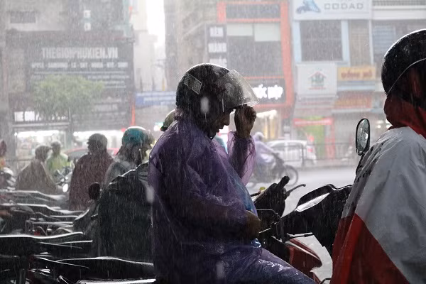 Phụ huynh đợi con trong mưa.