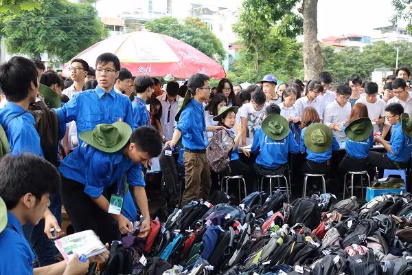 Đội tình nguyện viên đang giúp các thí sinh gửi vật dụng không được mang vào phòng thi.