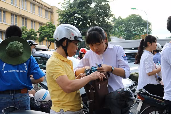 Phụ huynh cẩn thận kiểm tra lại giấy tờ, đồ dùng cho sĩ tử mang vào phòng thi.