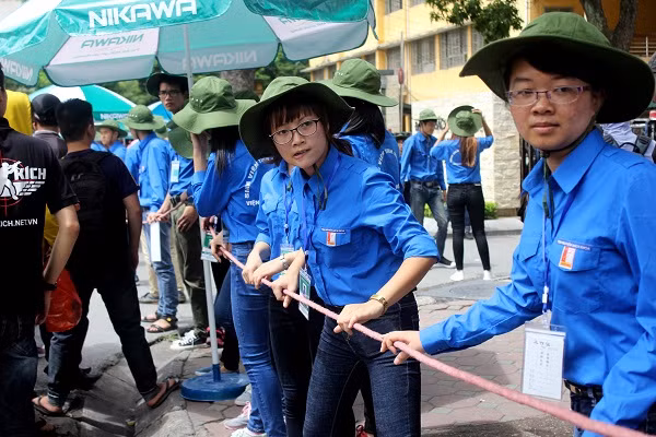 Đội tình nguyện viên đang tạo hàng rào dây để tránh ùn tắc trước điểm thi