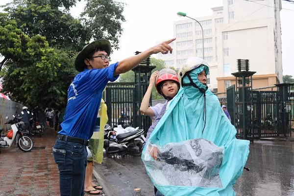 Bạn Phạm Minh Đức, thành viên đội tình nguyện SIE, đang chỉ dẫn phòng thi cho thí sinh.