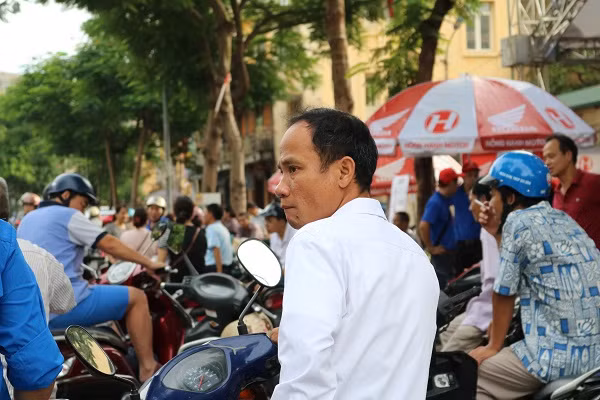 Một người cha căng thẳng chờ con bên ngoài trường thi.